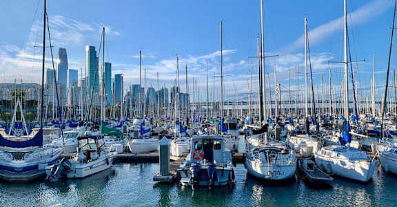 a harbor full of boats with a city in the background