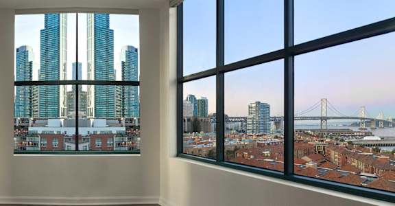 a view of the skyline from the window of a condo