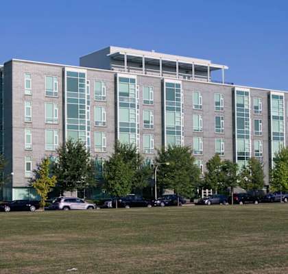 a large apartment building with cars parked in front of it