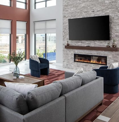 A modern living room with a grey sofa, a fireplace, and a large painting on the wall.at The Edison at Maple Grove, Maple Grove, 55311