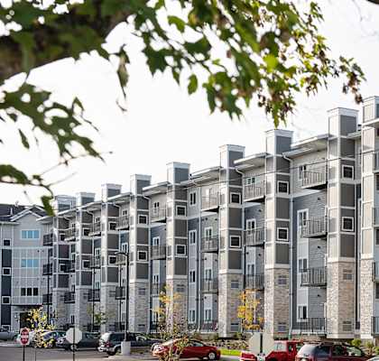 a large apartment building with cars parked in front of it