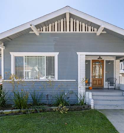 A house with a grey front and a white door.