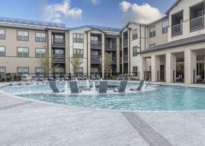 a swimming pool in front of an apartment building
