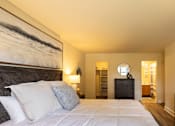 Thumbnail 8 of 17 - Bedroom with a bed and lamps on the wall at Woodridge Apartments, Randallstown, 21133