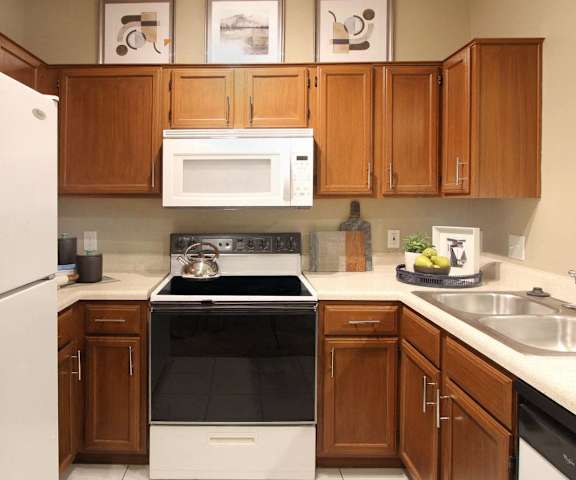 a kitchen with white appliances and wooden cabinets