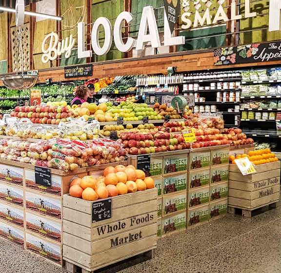 A sign in a grocery store that says "Responsibly Grown" above a section of fresh produce.