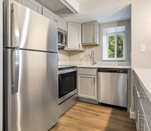 a kitchen with stainless steel appliances and white cabinets at Park 44, St. Louis, Missouri