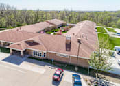 Thumbnail 1 of 5 - A building with a parking lot in front of it.