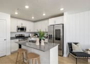 Thumbnail 2 of 10 - A kitchen with a white countertop and stainless steel appliances.