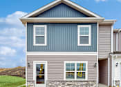 Thumbnail 28 of 30 - A house with a grey and blue exterior and a white garage door.