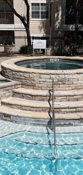 A pool with a fountain in the middle of it.