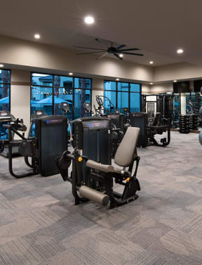 a spacious fitness room with cardio equipment and weights