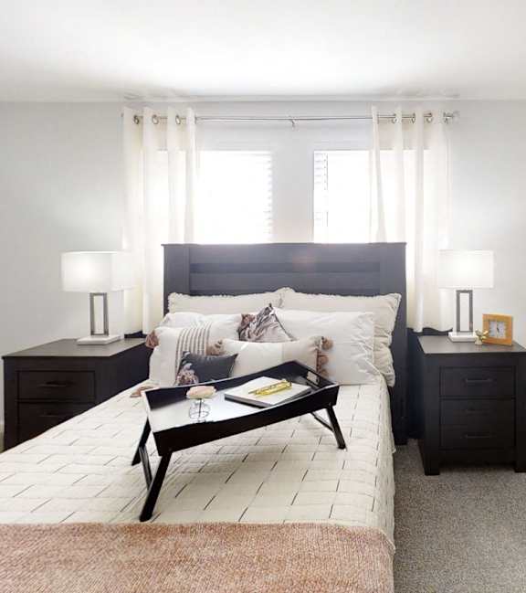 a bedroom with a bed and a dresser and a window