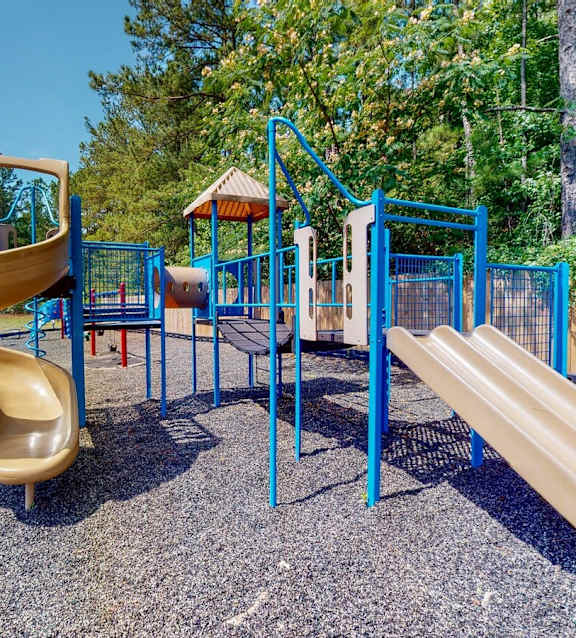 A playground with a yellow slide and blue railings.