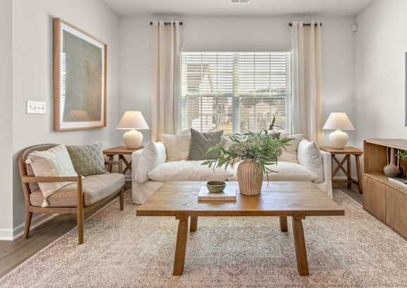 A living room with a wooden coffee table and two armchairs.