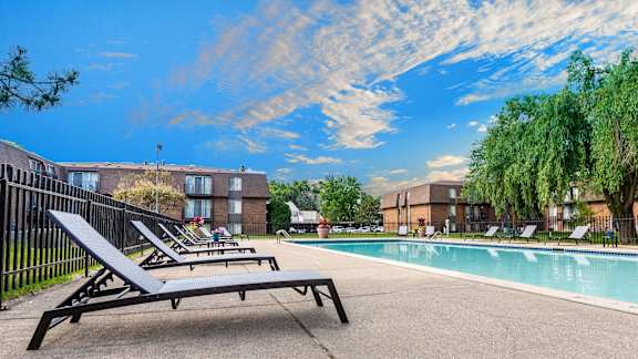 A sun lounger is on the edge of a pool.