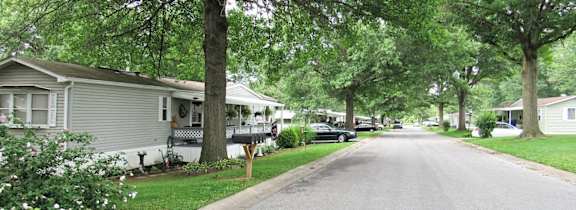 A residential street lined with houses and trees.