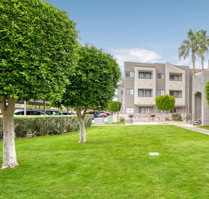 El Encanto outside view with nice lush grass area with trees around