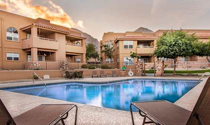 La Reserve Villas Community Pool with apartment building and mountains in the background.