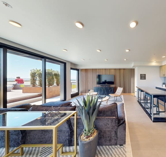 the living room and kitchen of a modern home with a view of the ocean