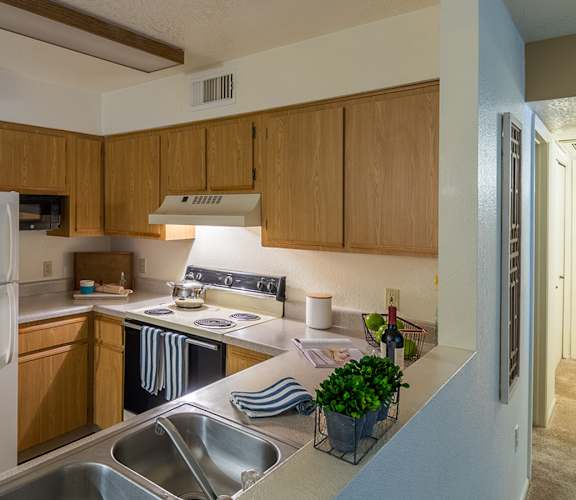 Estancia kitchen with plenty of cabinetry, a fridge, stove, and a sink