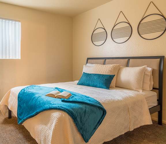 Enclave master bedroom with natural light and carpet flooring