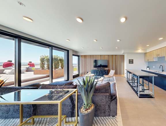 the living room and kitchen of a modern home with a view of the ocean
