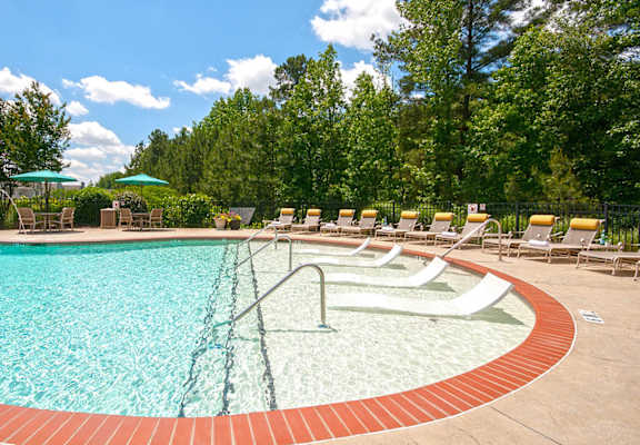 a swimming pool with chairs and umbrellas