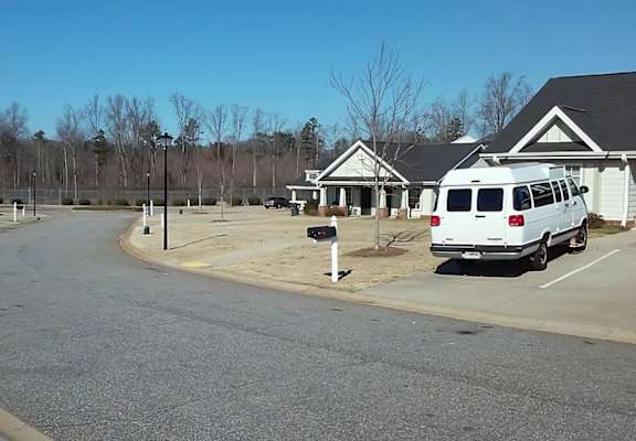 A white van is parked in a parking lot.
