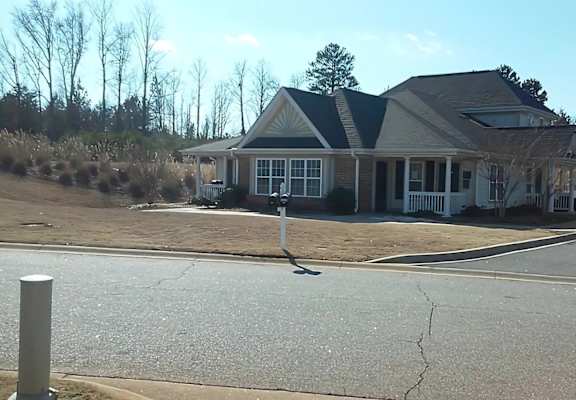 A house with a grey roof and a white fence.
