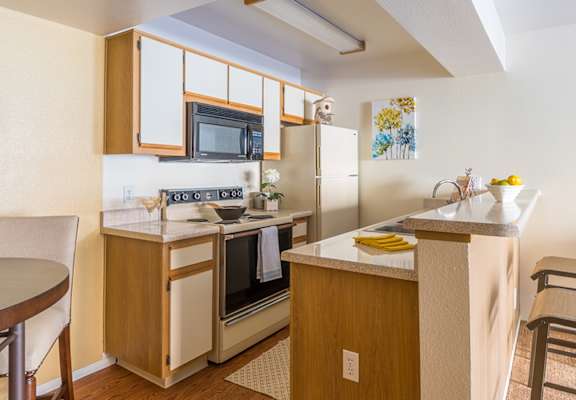 A kitchen with a table and chairs.