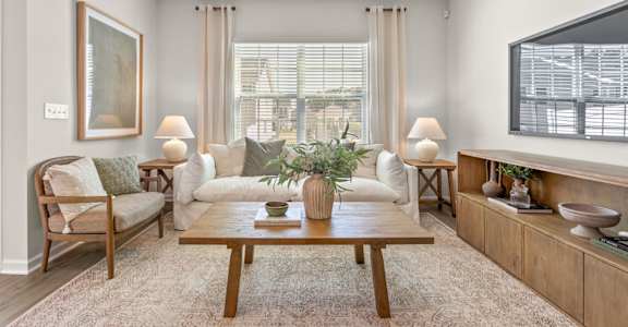 A living room with a wooden coffee table and two armchairs.