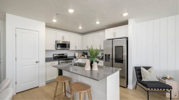 A kitchen with a white countertop and stainless steel appliances.