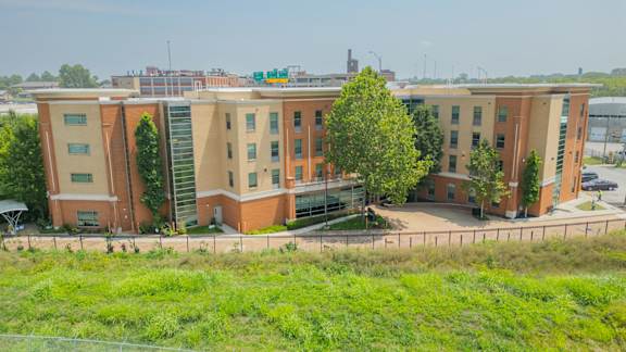 A large red brick building with a parking lot in front.