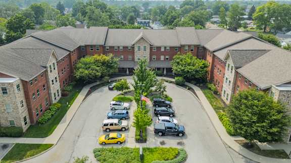 A parking lot in front of a large brick building with a sign that says "The Commons".