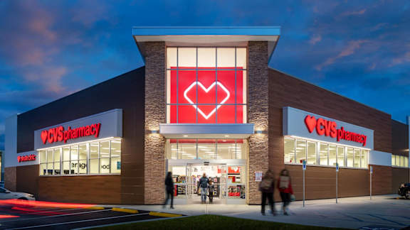 A CVS Pharmacy storefront with people walking by.