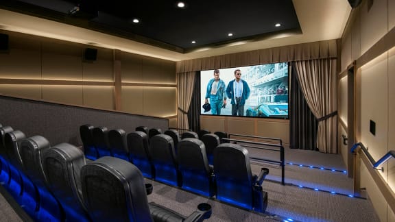 a large auditorium with a row of chairs and a staircase in a dark room