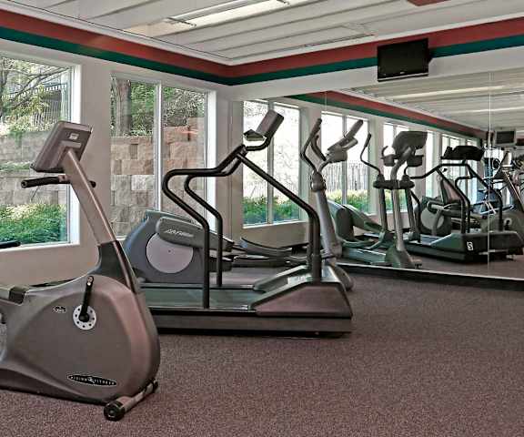 a gym with various exercise equipment in a room with windows