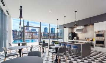 a kitchen with a large island with a breakfast bar and a large window with a city view