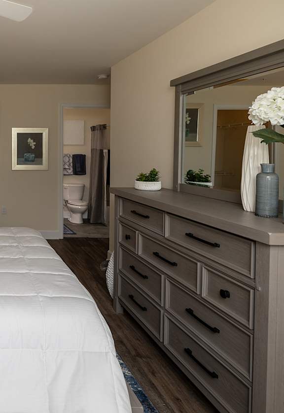 A bedroom with a large bed and a dresser.