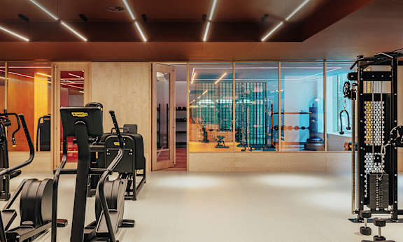A gym with treadmills, weights, and mirrors.