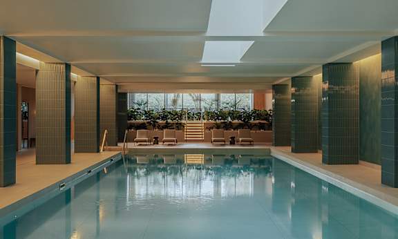 A large indoor swimming pool with a glass bottom.