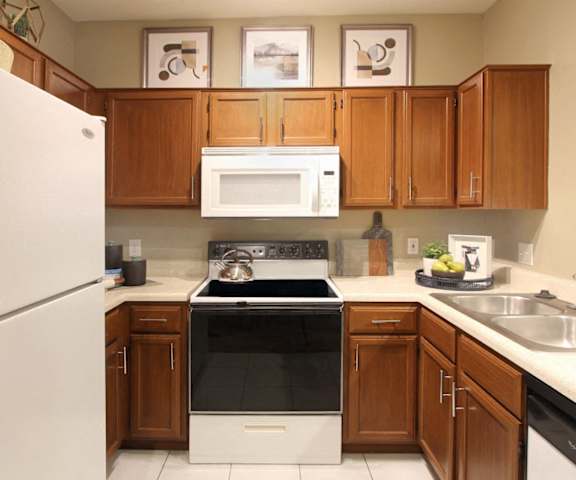 a kitchen with white appliances and wooden cabinets