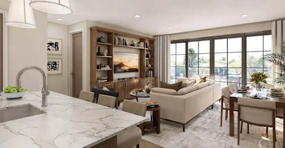 A modern kitchen with a marble countertop and a dining area with a couch and chairs.