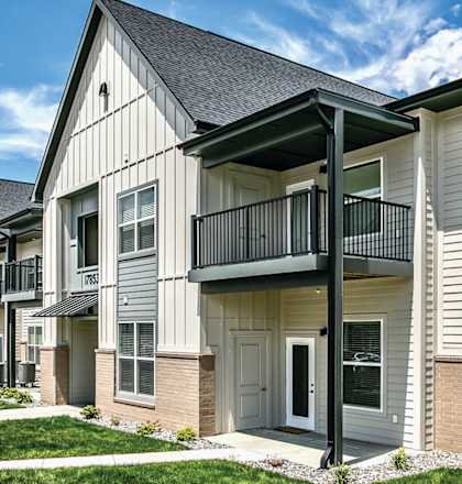 A row of townhomes with green grass and a blue sky in the background at Tiburon Ridge, Omaha, Nebraska
