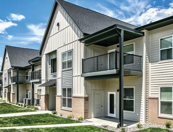 A row of townhomes with green grass and a blue sky in the background at Tiburon Ridge, Omaha, NE 68136