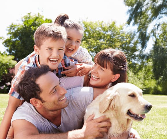 A family is enjoying a day out in the park with their dog.