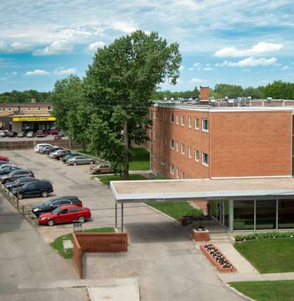 A parking lot with cars and a building in the background.