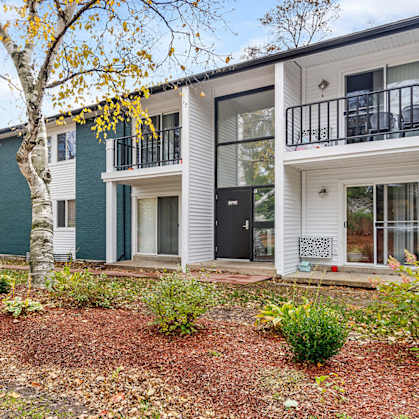 A row of modern townhouses with white and green exteriors.