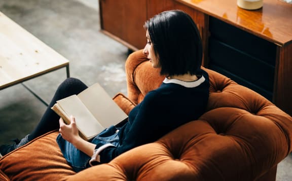 a woman sitting in a chair reading a book